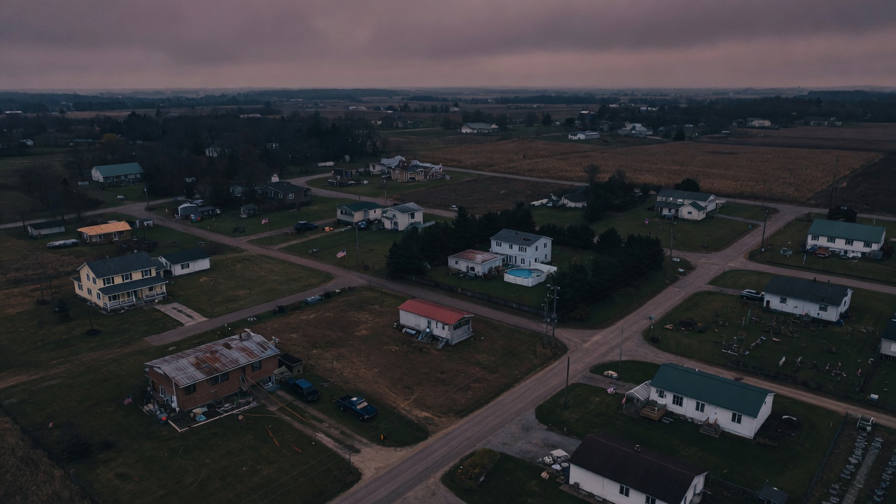 Dusk aerial of mixed suburban and rural houses — a nationwide desk staffed by local crews, not a fake city map.